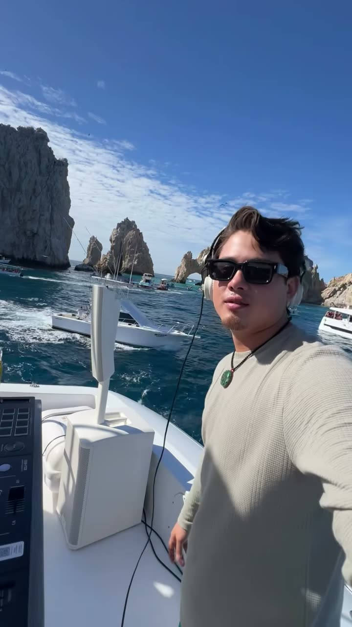 Valdi on a yacht deck beside his decks with the rock formations of Land’s End behind him