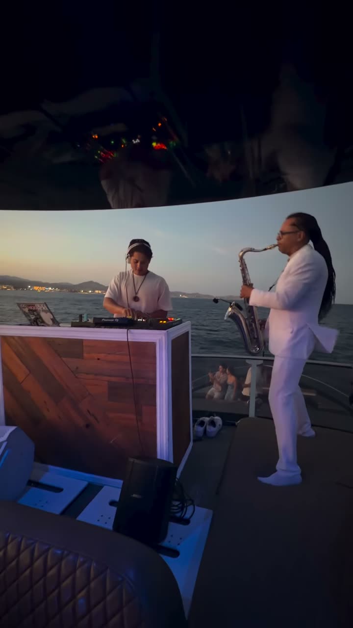 Valdi and a saxophonist playing on a yacht at sunset