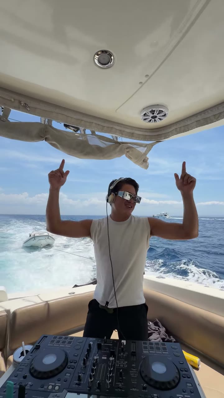 Valdi with both hands up at his decks on the back of a moving yacht
